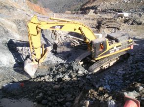 Construction excavator picking up rocks