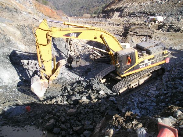 Construction excavator picking up rocks