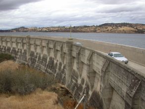 Cars driving next to dam