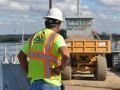 Construction worker overseeing work along river