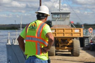 Construction worker overseeing work along river