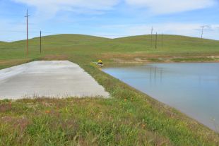 Grassy field with dam and levee