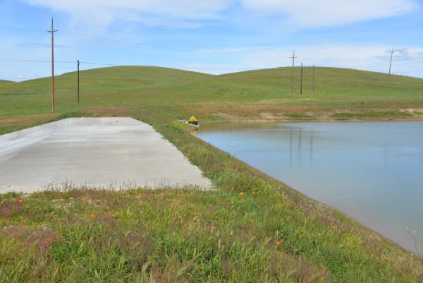 Grassy field with dam and levee