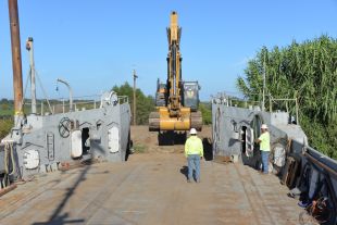 Construction worker overseeing work along river