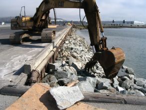 Construction excavator picking up rocks