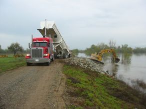 Construction trucks working on along river