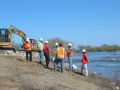 Construction workers overseeing work along river