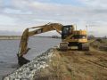 Construction excavator working on dam site
