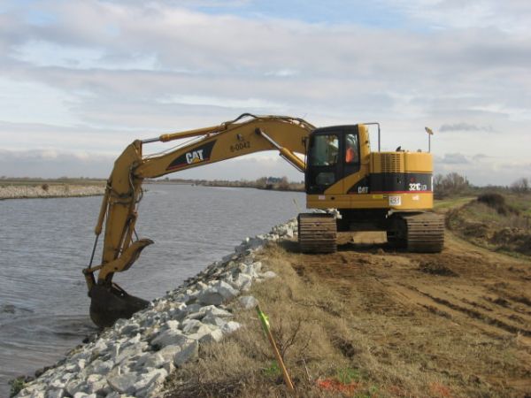 Construction excavator working on dam site